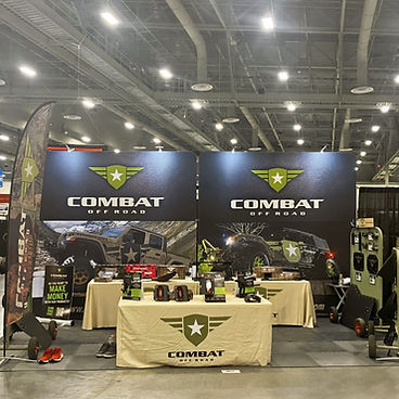 Combat Off Road trade show booth with banners and table displays